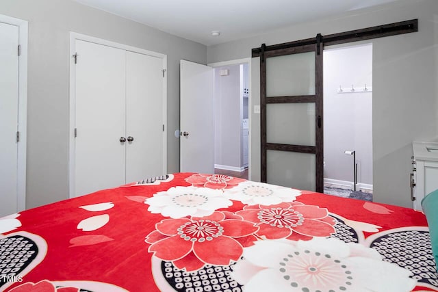 bedroom featuring a closet, a barn door, and baseboards