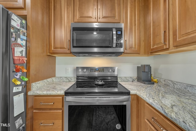 kitchen with stainless steel appliances and light stone countertops