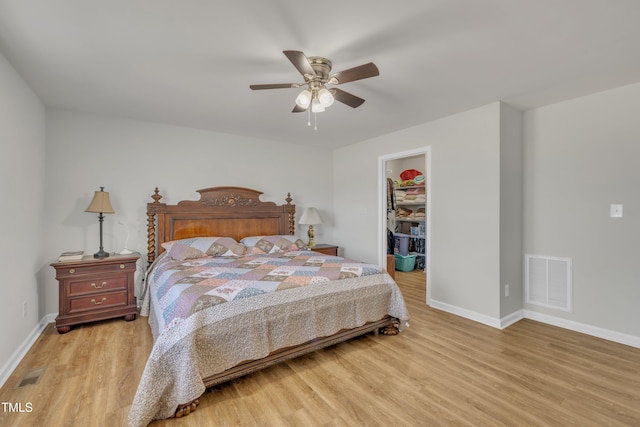 bedroom with visible vents, wood finished floors, and a spacious closet