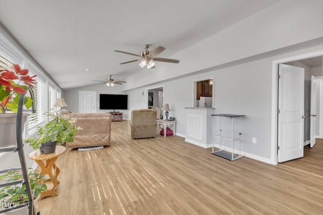 living area with light wood-style flooring, ceiling fan, baseboards, and vaulted ceiling