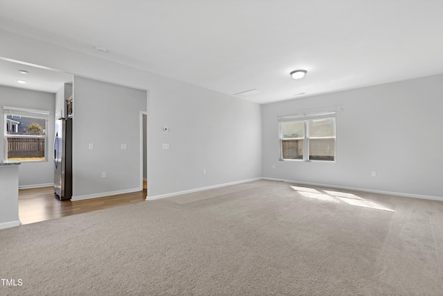 unfurnished room with carpet flooring and baseboards