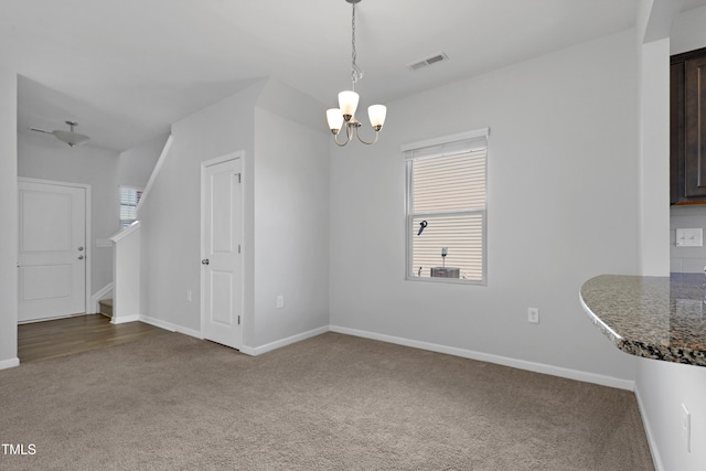 unfurnished dining area with stairway, carpet, visible vents, baseboards, and a notable chandelier