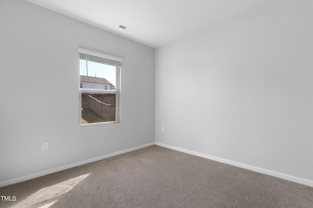 unfurnished room featuring baseboards, visible vents, and carpet floors