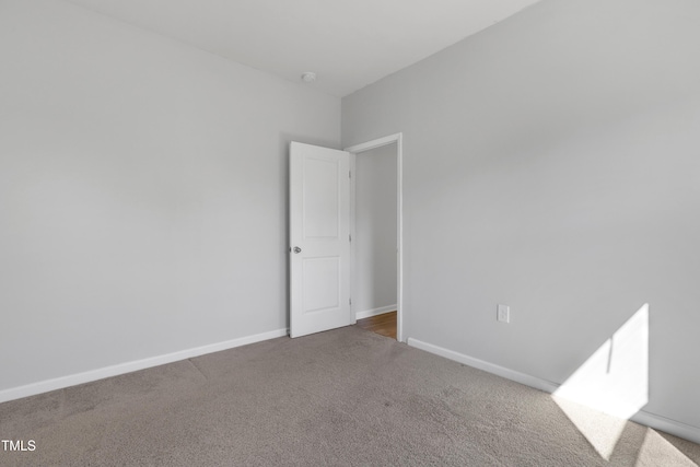 carpeted spare room with baseboards