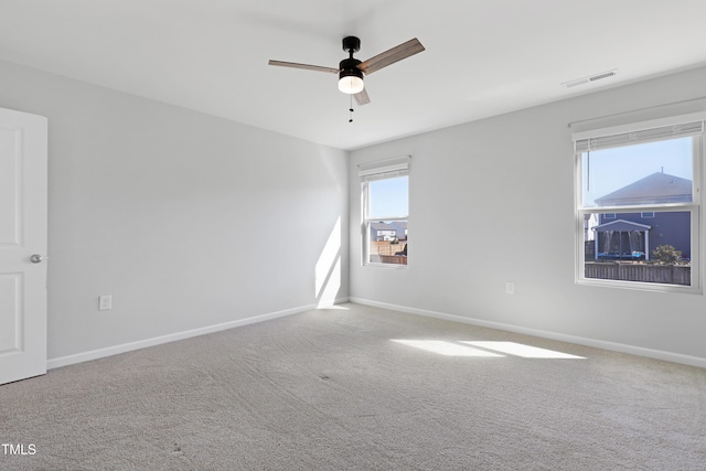 spare room with visible vents, a ceiling fan, baseboards, and carpet floors