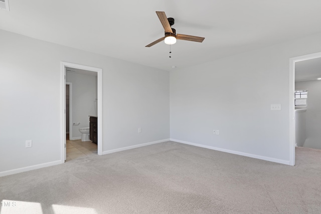 unfurnished bedroom with carpet flooring, baseboards, ensuite bathroom, and ceiling fan