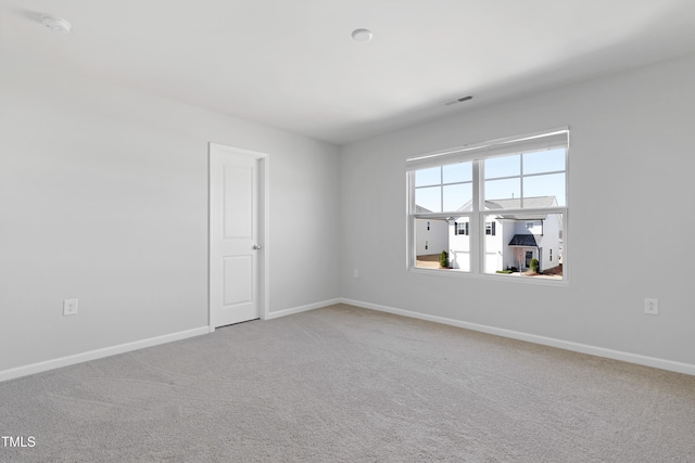 unfurnished room featuring carpet flooring, visible vents, and baseboards