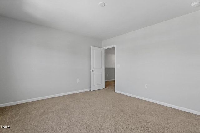 carpeted empty room featuring baseboards