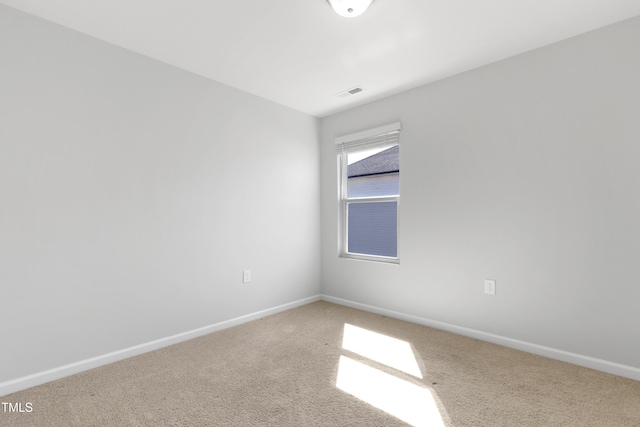 carpeted spare room with baseboards and visible vents