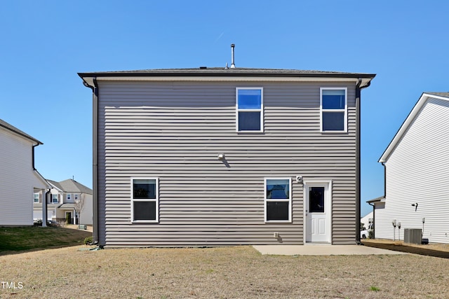 back of property with central air condition unit and a lawn