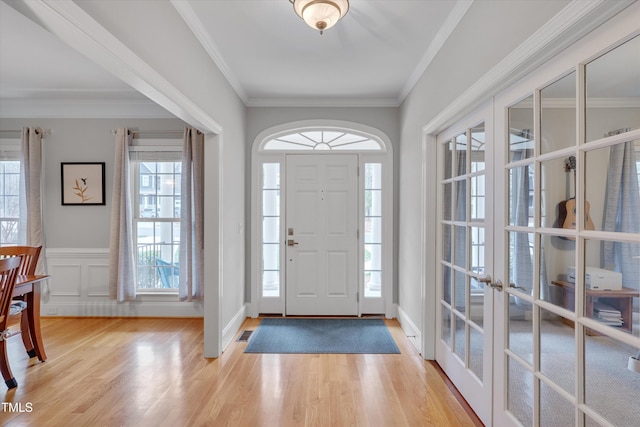 foyer with plenty of natural light, french doors, and light wood-type flooring