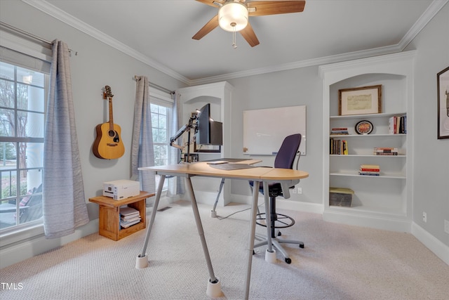 carpeted home office with baseboards, a ceiling fan, and crown molding