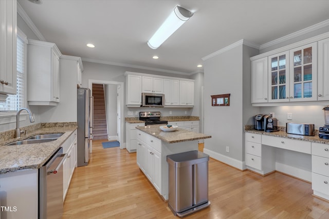 kitchen with white cabinets, light wood-style floors, appliances with stainless steel finishes, and a sink