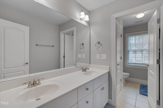 bathroom featuring visible vents, toilet, a sink, tile patterned flooring, and double vanity