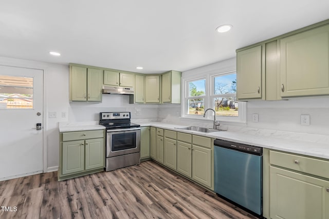 kitchen featuring green cabinets, under cabinet range hood, stainless steel electric range oven, dishwashing machine, and a sink