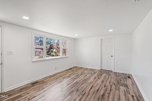 spare room featuring visible vents, recessed lighting, baseboards, and wood finished floors