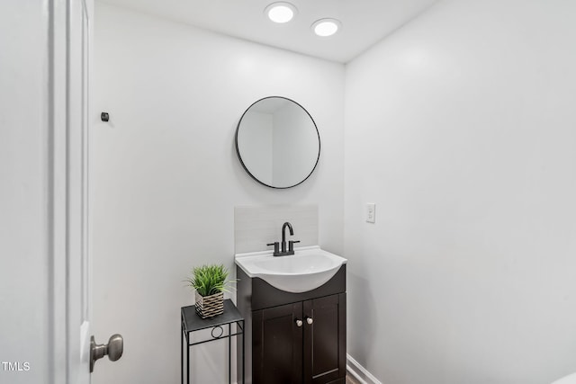 bathroom featuring baseboards, tasteful backsplash, and vanity