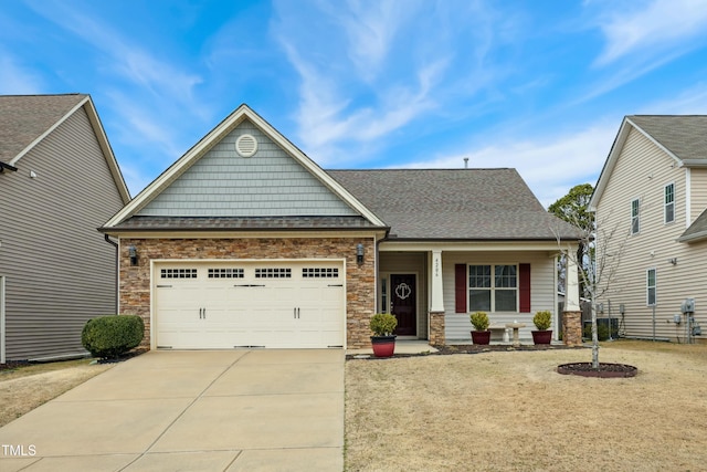 craftsman-style house featuring a garage, driveway, and a shingled roof