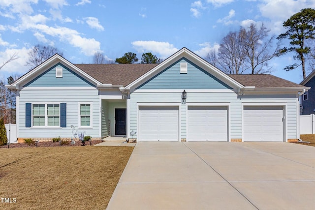 ranch-style home with concrete driveway, a garage, roof with shingles, and a front lawn