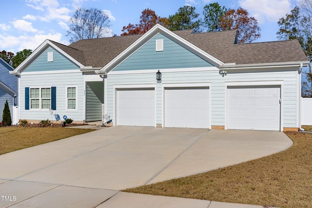 ranch-style house with an attached garage, concrete driveway, roof with shingles, and a front yard