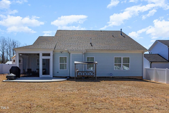 back of property with a patio, a fenced backyard, a sunroom, and roof with shingles