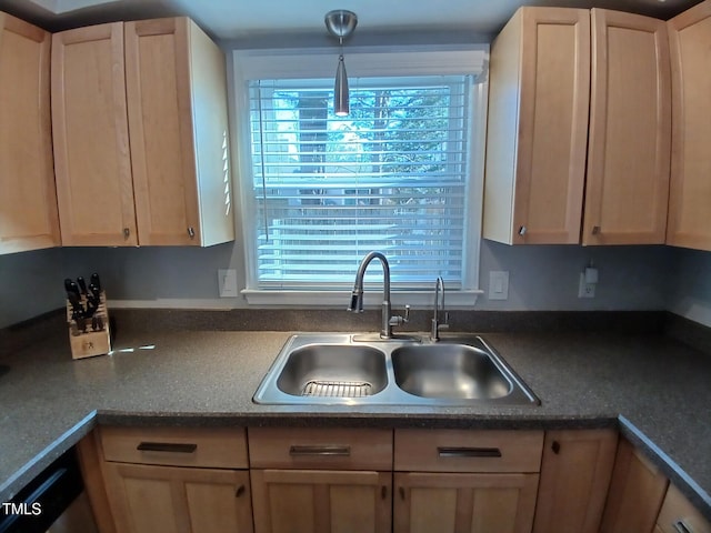 kitchen featuring dishwasher, dark countertops, light brown cabinetry, and a sink