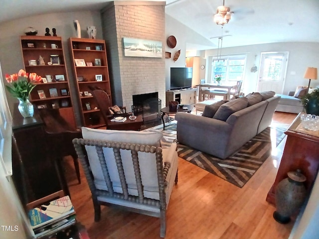 living room with lofted ceiling, wood finished floors, and a fireplace