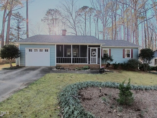 single story home with a front lawn, a chimney, a garage, a sunroom, and driveway