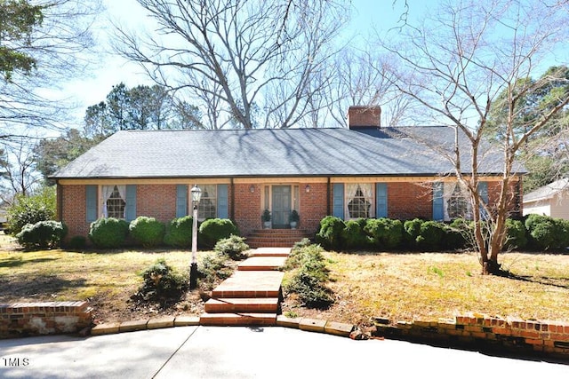 view of front of home featuring brick siding and a chimney