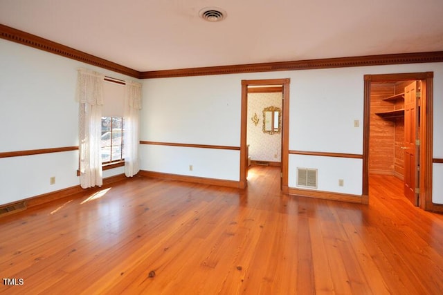 spare room with visible vents, baseboards, and hardwood / wood-style floors