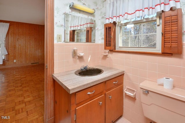 bathroom featuring visible vents, toilet, wallpapered walls, and vanity