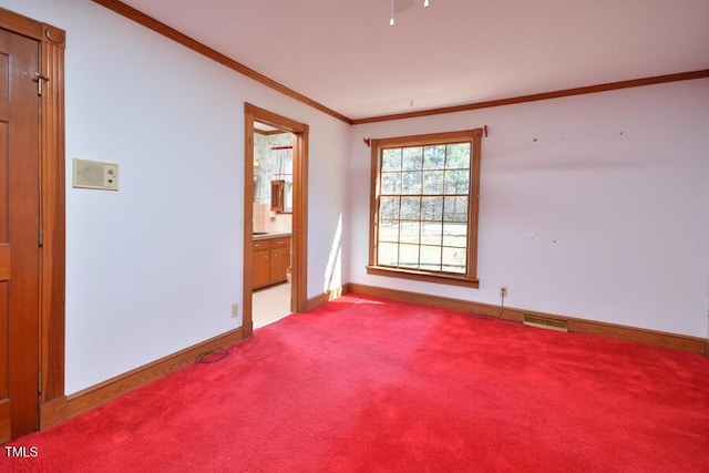 empty room with visible vents, carpet flooring, baseboards, and ornamental molding