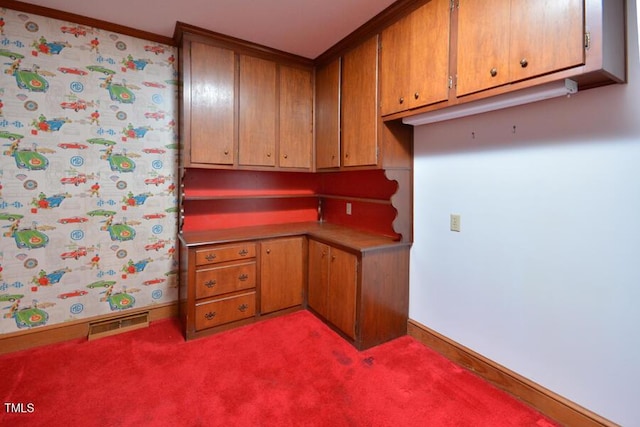 kitchen with baseboards, visible vents, light countertops, light colored carpet, and brown cabinets