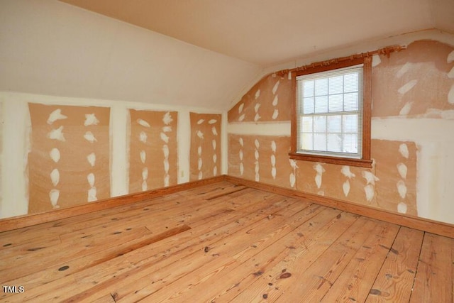 bonus room with hardwood / wood-style flooring and vaulted ceiling