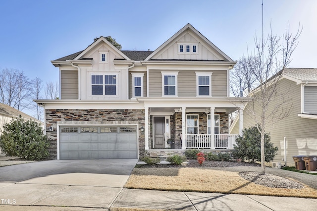 view of front of house with driveway, a porch, an attached garage, stone siding, and board and batten siding