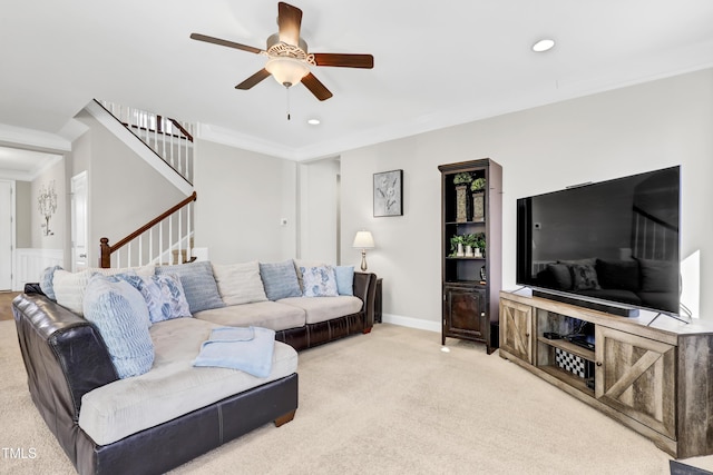 carpeted living area featuring a ceiling fan, baseboards, recessed lighting, stairs, and crown molding