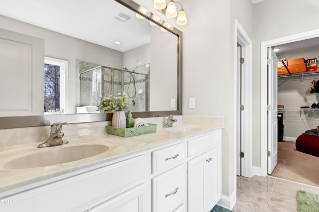 full bath featuring a shower stall, a spacious closet, double vanity, and a sink