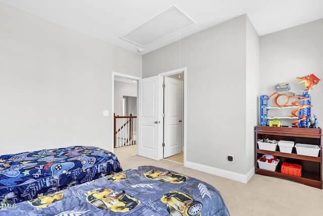 carpeted bedroom with attic access and baseboards