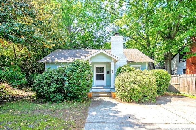 view of front of home with a chimney and fence