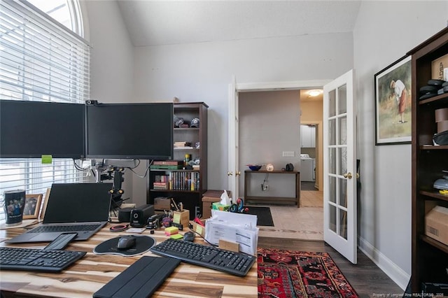 home office with wood finished floors, baseboards, washer / dryer, vaulted ceiling, and french doors