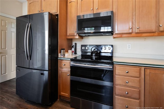 kitchen with light countertops, double oven range, dark wood-type flooring, and freestanding refrigerator