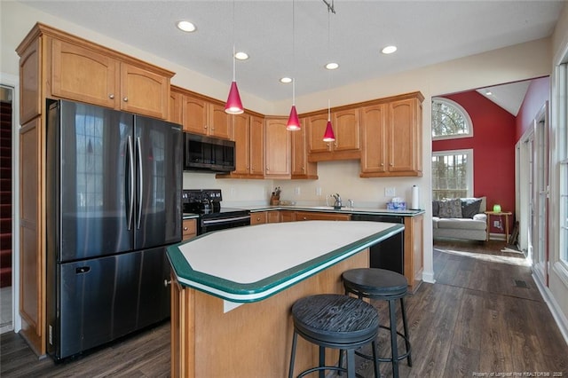 kitchen featuring a kitchen island, dark wood finished floors, vaulted ceiling, black appliances, and a sink