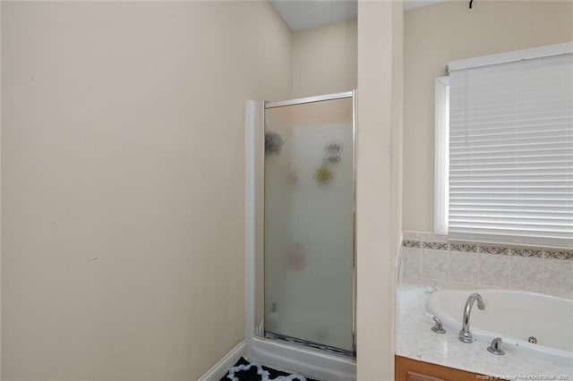 full bathroom with a jetted tub and a shower stall