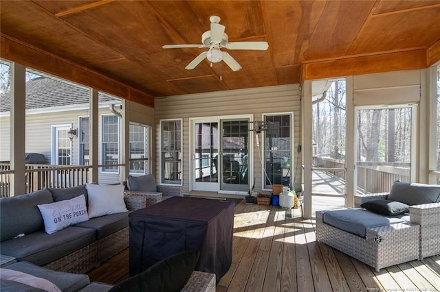 sunroom featuring wood ceiling and a ceiling fan