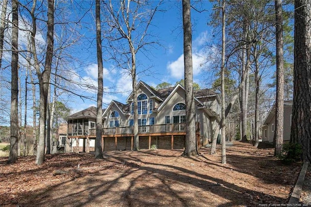 back of property featuring a deck and a sunroom