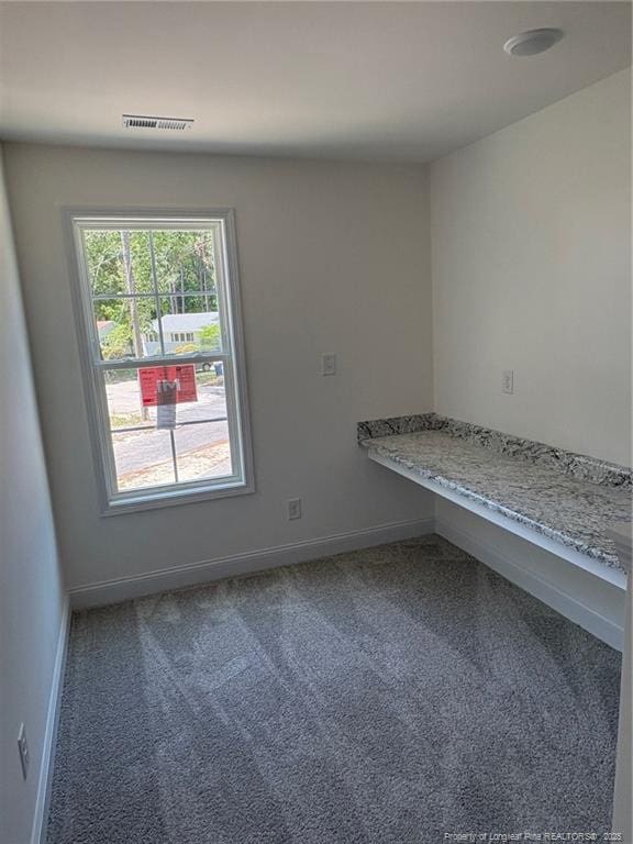 carpeted spare room featuring baseboards