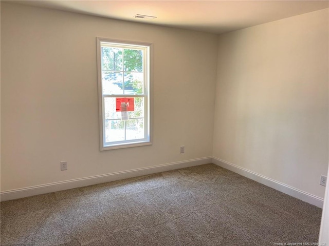 carpeted spare room featuring baseboards