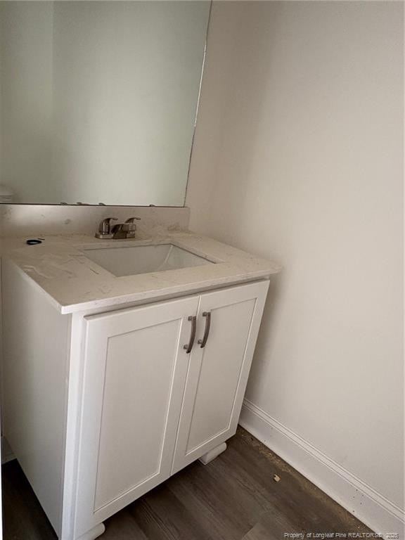 bathroom featuring wood finished floors, vanity, and baseboards