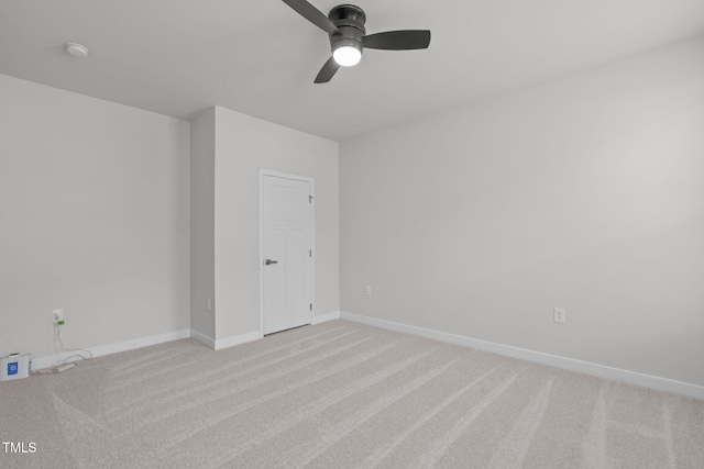 empty room featuring ceiling fan, baseboards, and light carpet