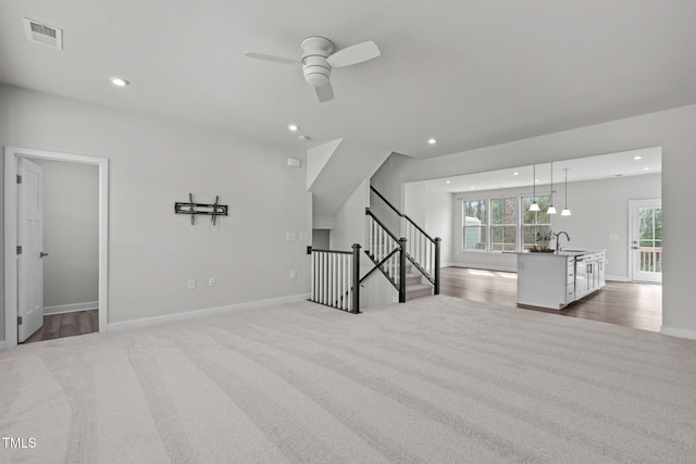 unfurnished living room with recessed lighting, visible vents, a ceiling fan, and carpet flooring